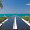VELCRO® Brand Industrial Strength Extreme Hook and Loop Strips (10 Pack) are pictured here on a sleek black table with a white stripe, set outdoors by turquoise waters, palm trees, and greenery under a clear blue sky.