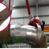 A worker in protective gear secures insulation around large pipes with VELCRO® Brand HI GARDE® Fasteners in an industrial setting an inset highlights a close up of the brown fibrous insulation