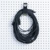 A long black audio cable hangs neatly on a white pegboard secured by a Cord Lox® HangMaster™ ProSeries Heavy Duty Hook  Loop Cable Hanging  Storage Strap with metal grommet for organized XLR cable storage