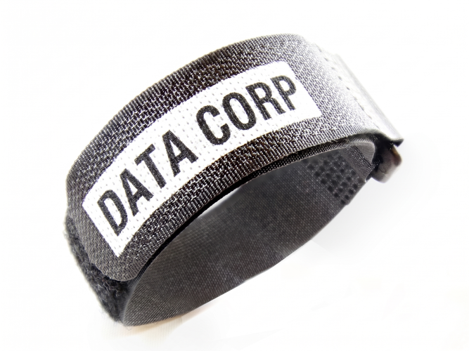 A black fabric wristband with a white label that reads DATA CORP in bold black letters displayed on a white background TFI Custom Fabrication A black fabric wristband with a white label that reads DATA CORP in bold black letters displayed on a white background